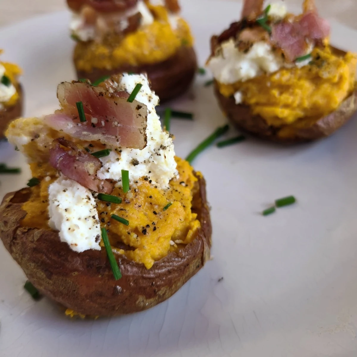 Golden, bubbly Loaded Sweet Potato Skins topped with crisp bacon and fresh chives, ready to enjoy.