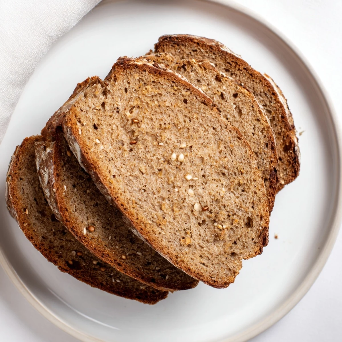 Golden-brown Latvian Rupjmaize bread, fresh from the oven, offering a tempting glimpse of its rustic, textured surface.
