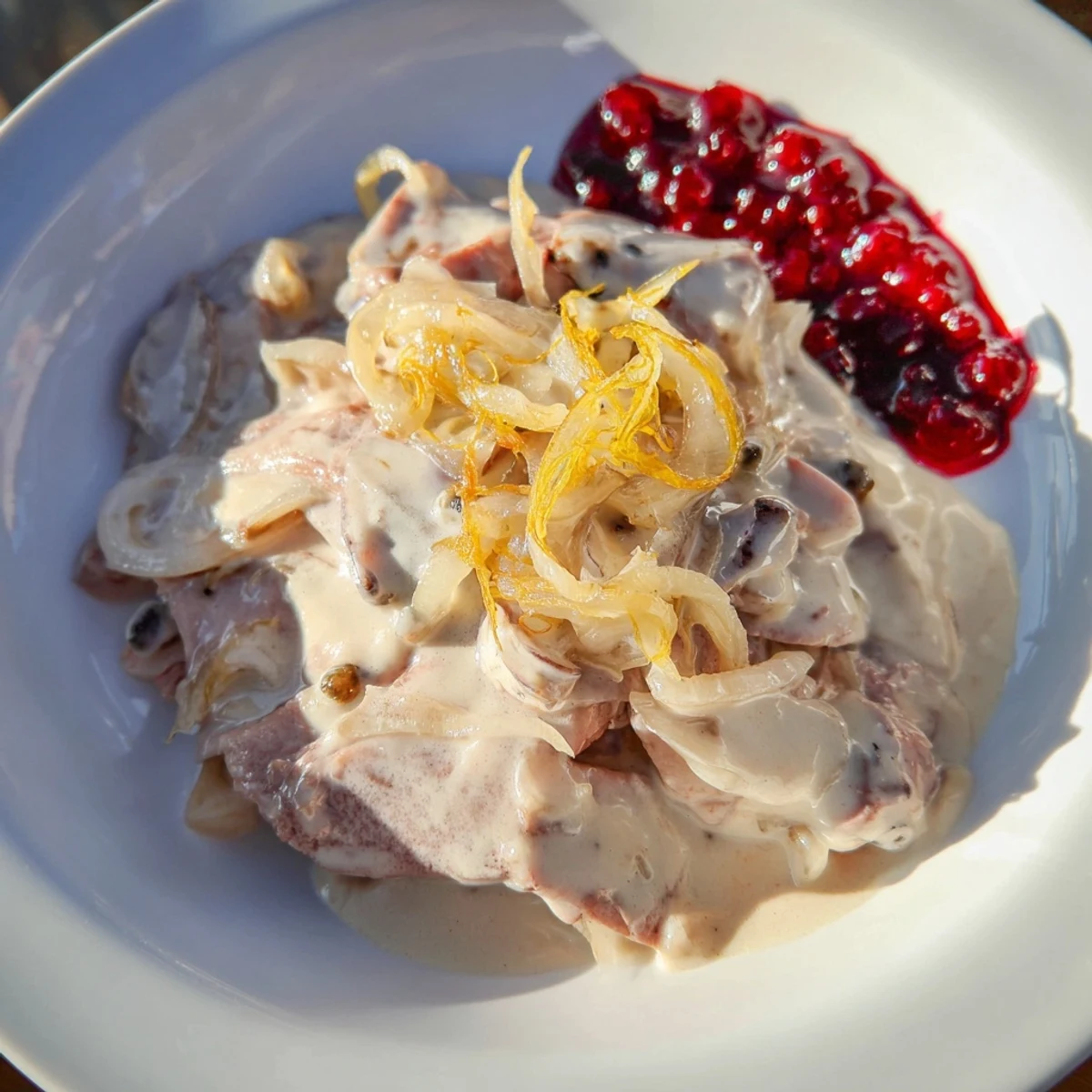 A steaming bowl of Finnish Reindeer Stew, showcasing tender meat and a creamy, rich sauce.