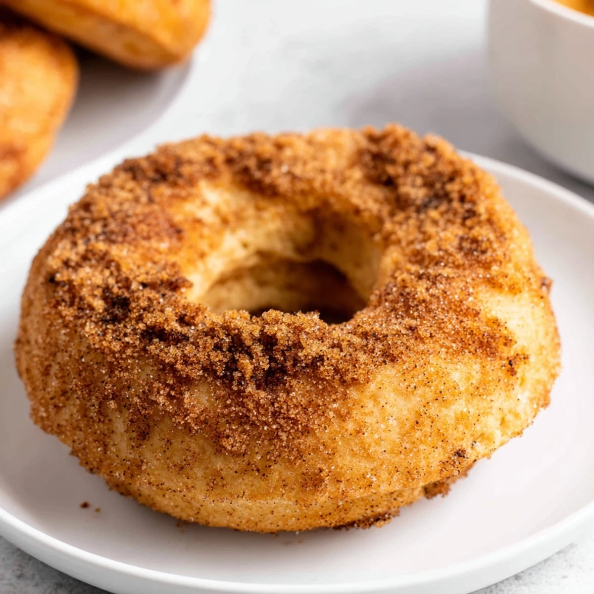 Warm, pillowy Air Fryer Cinnamon Sugar Donuts arranged on a plate, ideal for cozy afternoons with a glass of milk.