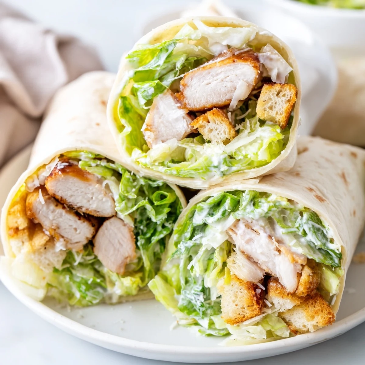 Freshly grilled chicken slices rest on crisp romaine lettuce, parmesan, and croutons, all wrapped in a soft flour tortilla for a handheld Caesar Chicken Salad Wrap.