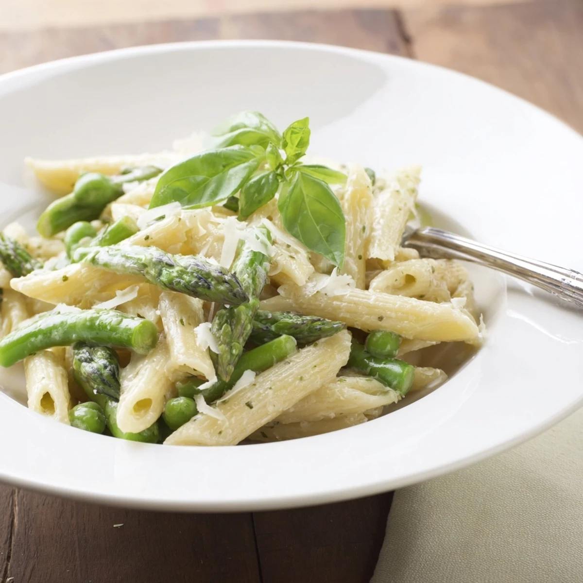 Garlic Parmesan Spring Vegetable Pasta tossed with crisp vegetables, a velvety sauce, and extra Parmesan in a skillet, ready to serve.