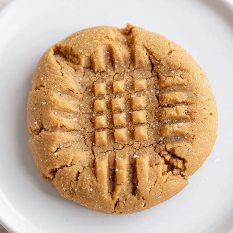 Close-up shot showing the soft texture and crisscross pattern of gluten-free flourless peanut butter cookies.