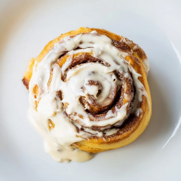 Warm Pillow Soft Cinnamon Rolls paired with a steaming mug of coffee for a cozy breakfast.