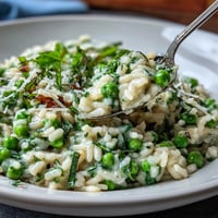 Creamy spring pea risotto with mint and Parmesan, a vibrant Italian dinner.
