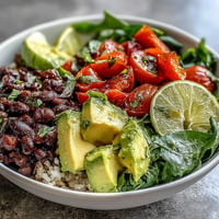 Vibrant plant-based taco bowl with chunky black beans and fresh salsa topping.